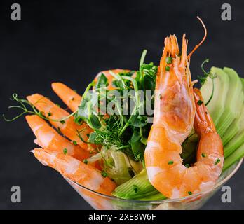 Gamberi e pezzi di avocado in un bicchiere di martini Foto Stock