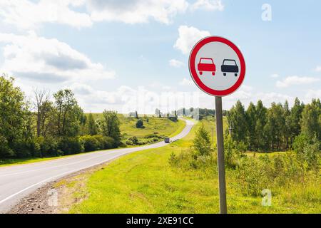 In una soleggiata giornata estiva, è vietato effettuare sorpassi sullo sfondo di una strada tortuosa Foto Stock