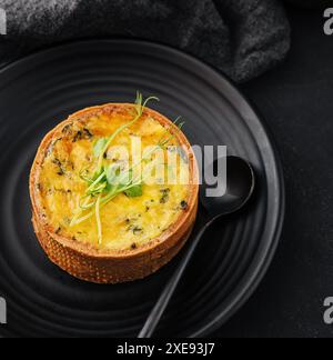 Piastra di mini quiche su piastra nera Foto Stock