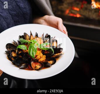 Deliziose cozze appena cotte al vapore in salsa di vino bianco in un piatto bianco Foto Stock