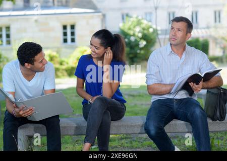 la gente sedeva in panchina nel campus universitario Foto Stock