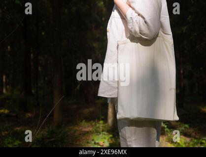 . Borsa tote in tela con mockup sulla spalla femminile, sfondo foresta naturale. Banner.. Foto Stock