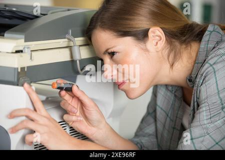 donna sta riparando una stampante Foto Stock