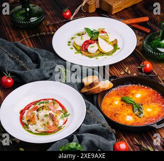 Diversi tipi di piatti italiani su un grande tavolo di legno Foto Stock