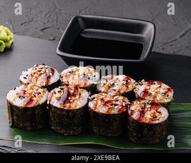 Futomaki tradizionale sushi giapponese fresco su pietra nera Foto Stock