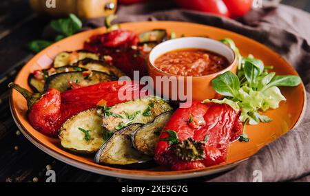 Verdure colorate alla griglia, melanzane, zucchine, pepe con spezie e basilico verde Foto Stock