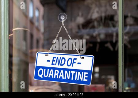 Primo piano su un segno blu in una finestra scritta all'interno di "fine quarantena". Foto Stock