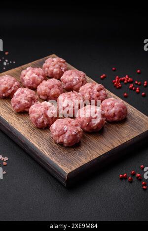 Polpette crude di carne macinata di manzo, maiale o pollo con sale, spezie ed erbe aromatiche Foto Stock