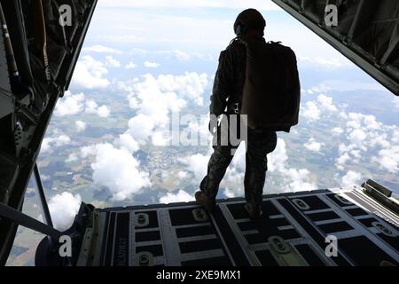 U.S. Marine Gunnery Sergeant Patrick Doody, Paraloft Chief, Bravo Company, 4th Reconnaissance Battalion, 4th Marine Division osserva il Military Free-Fall Team in volo dalla rampa di un Kentucky Air National Guard C-130 come principale maestro di salto prima di uscire durante l'esercitazione Baltic Operations (BALTOPS) 24 a Gotland, Svezia, 8 giugno 2024. I Reconnaissance Marines hanno condotto i salti a caduta libera come parte della loro formazione di inserimento, contingenza ed esfiltrazione, consentendo loro di operare in ambienti austeri. BALTOPS 24 è la principale esercitazione marittima nella Repubblica baltica Foto Stock