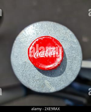 Kiel, Germania - 26 giugno 2024: Un tappo corona ammaccato del marchio di bevande Coca Cola Foto Stock