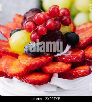 Mini torta di meringa pavlova decorata con frutti di bosco freschi Foto Stock