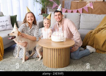 Famiglia felice con il cane Labrador che festeggia il compleanno a casa Foto Stock