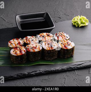 Futomaki tradizionale sushi giapponese fresco su pietra nera Foto Stock