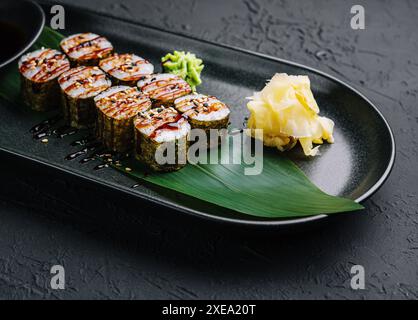 Tradizionale futomaki di sushi giapponese fresco su piatto nero Foto Stock