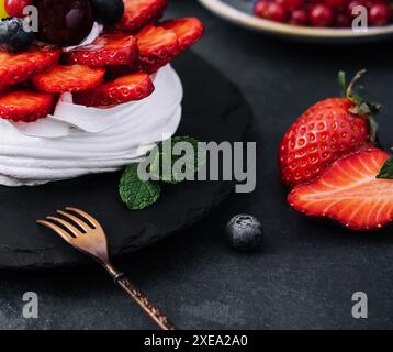 Mini torta di meringa pavlova decorata con frutti di bosco freschi Foto Stock