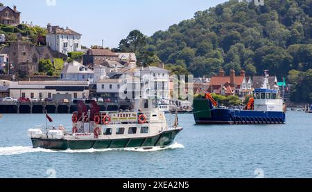 Traghetto passeggeri Christie Belle che naviga a Dartmouth sulle acque calme con una pittoresca cittadina e verdi colline sullo sfondo. Foto Stock