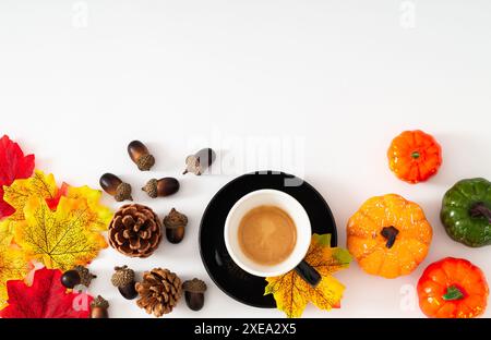 Scena autunnale o autunnale con tazza di caffè, foglie autunnali colorate, varie zucche, pinne e noci con spazio per copiare su sfondo bianco. Foto Stock