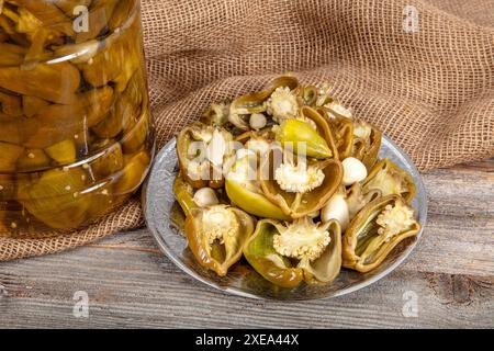 Peperoni greci dorati sottaceto, peperoncino o friggitello (toscano, Stavros, Capsicum annuum). I peperoni caldi sono marinati, sottaceto. Peperoni sottaceto in a. Foto Stock