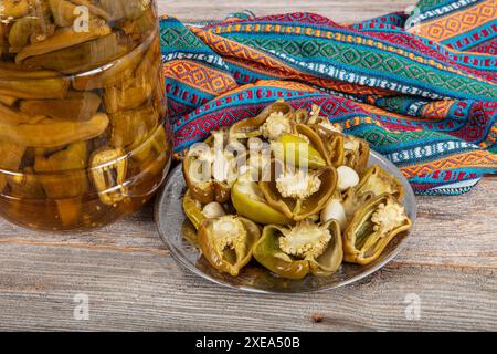 Peperoni greci dorati sottaceto, peperoncino o friggitello (toscano, Stavros, Capsicum annuum). I peperoni caldi sono marinati, sottaceto. Peperoni sottaceto in a. Foto Stock