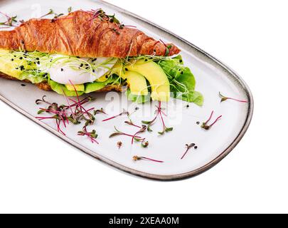 Croissant di salmone benedict con uova strapazzate, servito con insalata fresca Foto Stock