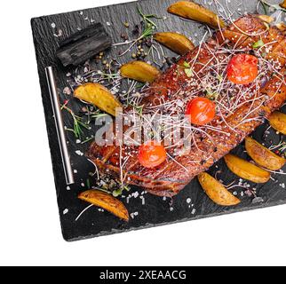 Gustoso filetto di maiale al forno in glassa miele-arancia con spicchi di patate Foto Stock