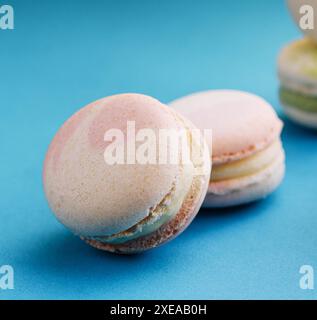 Macaron dolci e colorati su sfondo blu Foto Stock