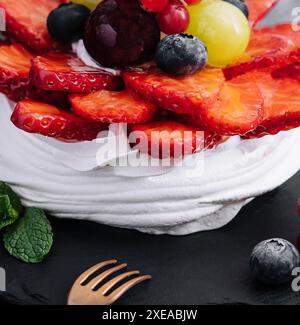 Mini torta di meringa pavlova decorata con frutti di bosco freschi Foto Stock