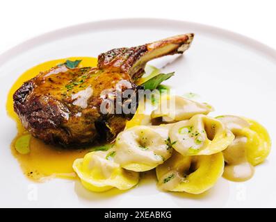 Bistecca di Tomahawk e ravioli sul piatto Foto Stock