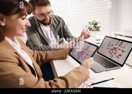 Cartografi che lavorano con la mappa catastale su tablet al tavolo bianco in ufficio Foto Stock