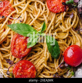 Spaghetti vegetariani con pesto al basilico e pomodori ciliegini Foto Stock