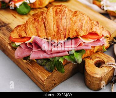 Delizioso panino di croissant su tavola di legno Foto Stock