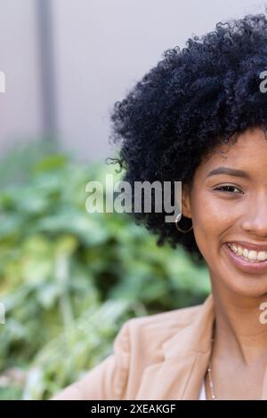 Godetevi una pausa all'aperto, una donna sorridente in un abbigliamento casual per affari Foto Stock