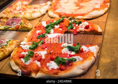 Molte fette di pizza sul tavolo di legno Foto Stock