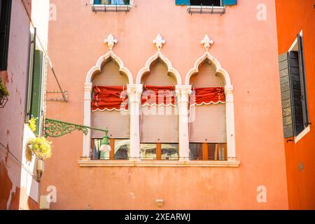 Windows su parete rossa nella vecchia casa Foto Stock