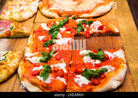 Molte fette di pizza sul tavolo di legno Foto Stock