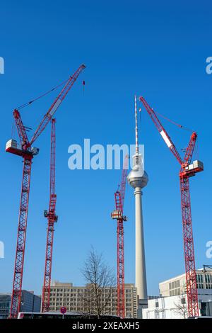 La famosa torre della televisione di Berlino con quattro gru a torre rosse Foto Stock