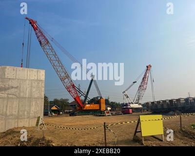 gru cingolata. Gru cingolata gialla elettrica diesel in un grande cantiere, comprese diverse gru che lavorano in un complesso edilizio, Foto Stock