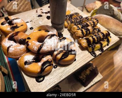 Ciambelle e churros aromatizzati al cioccolato con spolverini di zucchero. ciambelle e churros Foto Stock