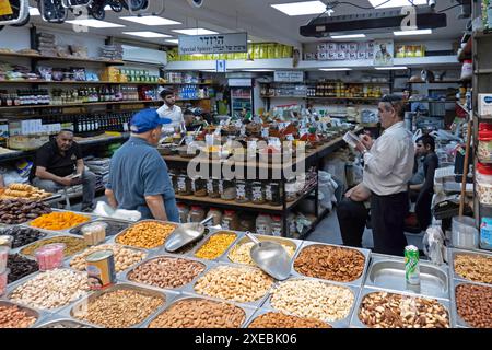 GERUSALEMME - GIUGNO 26: Un gruppo di ebrei israeliani pregano in un negozio di spezie a Mahane o al mercato di Machane Yehuda spesso indicato come "The Shuk", un mercato all'aperto, tra continue battaglie tra Israele e il gruppo militante Hamas nella striscia di Gaza il 26 giugno 2024 a Gerusalemme Ovest. Israele Foto Stock