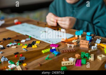 repubblica Ceca, Krecovice - 31 dicembre 2023: Boy assembla LEGO secondo le istruzioni Foto Stock