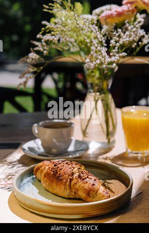 Tazza di caffè caldo fresco, succo d'arancia e tradizionale croissant francese sul tavolo del caffè parigino all'aperto a parigi Foto Stock
