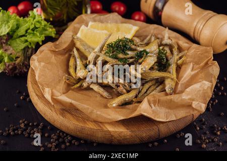 Pesce fritto caldo con sale ed erbe su carta marrone Foto Stock