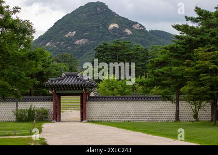 Bugaksan sorge dietro il Palazzo Gyeongbokgung, fornendo uno sfondo maestoso all'iconica residenza reale di Seul. Foto Stock