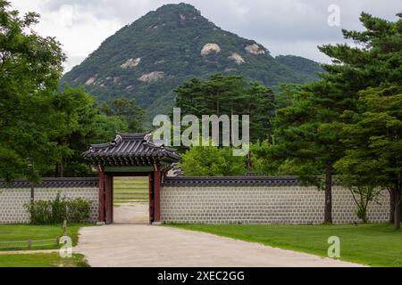 Bugaksan sorge dietro il Palazzo Gyeongbokgung, fornendo uno sfondo maestoso all'iconica residenza reale di Seul. Foto Stock