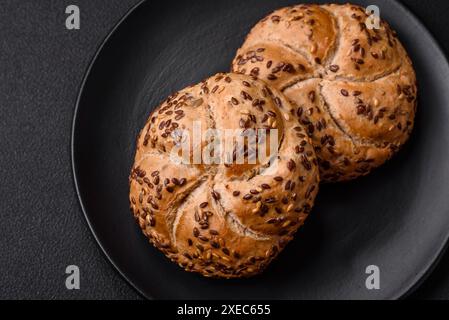 Delizioso panino croccante appena sfornato o panino kaiser con semi di sesamo Foto Stock