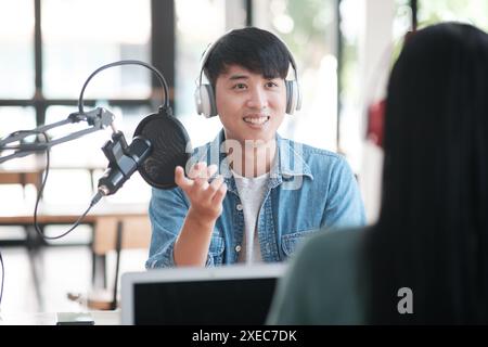 Un uomo che indossa le cuffie sta parlando con una donna. Foto Stock