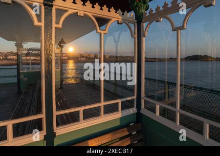 Il tramonto si riflette nei rifugi di vetro sul molo di Clevedon, Clevedon, Somerset, Inghilterra. Estate (luglio) 2019. Foto Stock