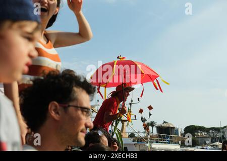 ACI TREZZA, ITALIA - 24 GIUGNO 2024 - Festa tradizionale di San Giovanni. Sfilata tradizionale di San Giovanni con pisci a mari dove riproducono la caccia al tonno. Il tonno viene derubato da un giovane che finalmente riesce a fuggire dai pescatori Foto Stock