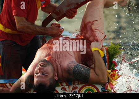 ACI TREZZA, ITALIA - 24 GIUGNO 2024 - Festa tradizionale di San Giovanni. Sfilata tradizionale di San Giovanni con pisci a mari dove riproducono la caccia al tonno. Il tonno viene derubato da un giovane che finalmente riesce a fuggire dai pescatori Foto Stock