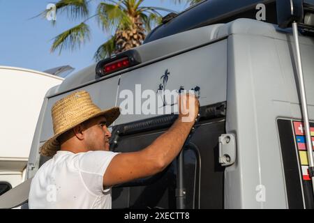 Artista marocchino che dipinge arte decorativa su un camper nel centro di Tiznit Foto Stock